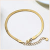 A gold-toned stainless steel snake chain anklet worn on a wrist, displayed against a white background.