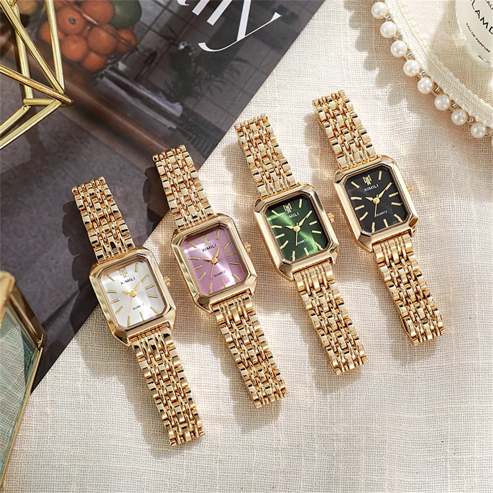 A collection of five gold plated quartz fashion watches with various colored dials and textured metal bands.