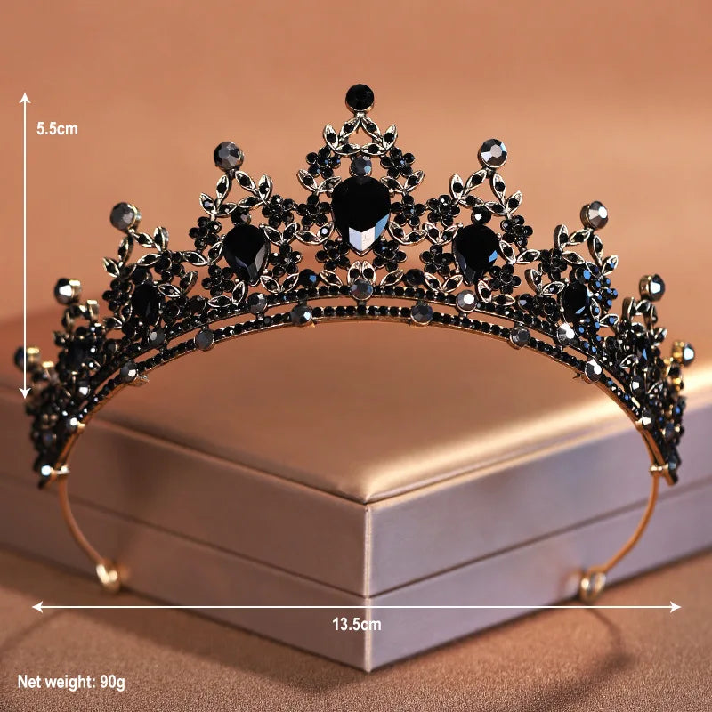A black and silver crystal baroque bridal tiara headpiece displayed on a box with a measurement scale.