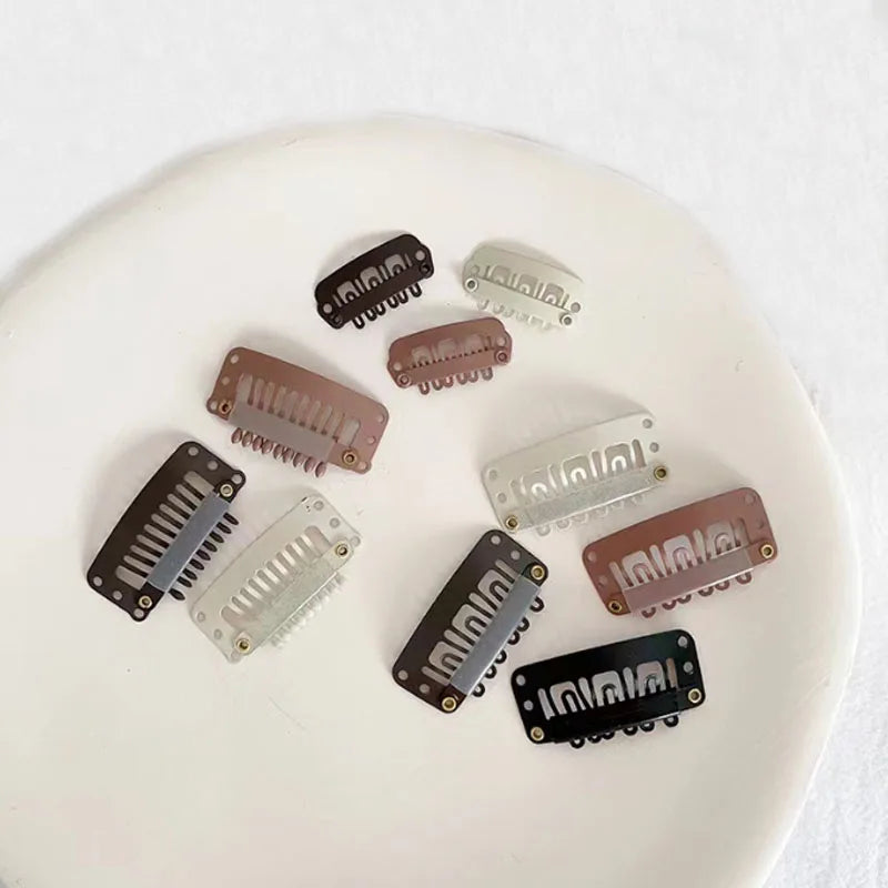 A collection of precision hair extension clips in various shades of brown and silver resting on a white surface.