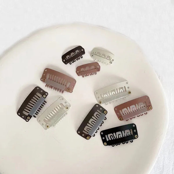 Una colección de pinzas para extensiones de cabello de precisión en varios tonos de marrón y plata sobre una superficie blanc