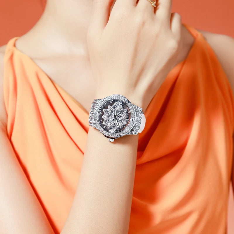 Gros plan d'une femme portant une montre en diamant argenté à son poignet, contre un vêtement orange.