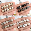 A collection of elegant button brooch pins featuring various floral and geometric designs in silver and black enamel.